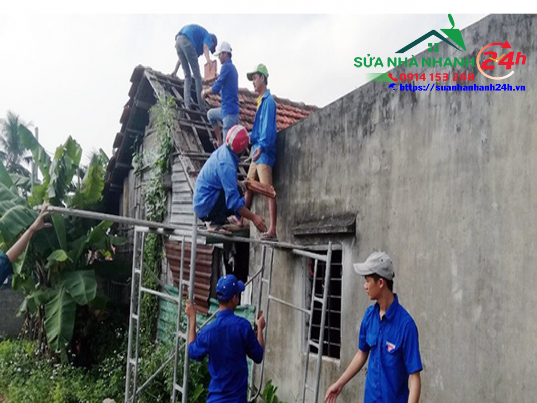 Những người thợ áo xanh của “đội thợ 0 đồng” xã Đức Ninh tất bật sửa xong ngôi nhà cho bà Đặng Thị Châu để kịp đón tết - Ảnh: QUỐC NAM